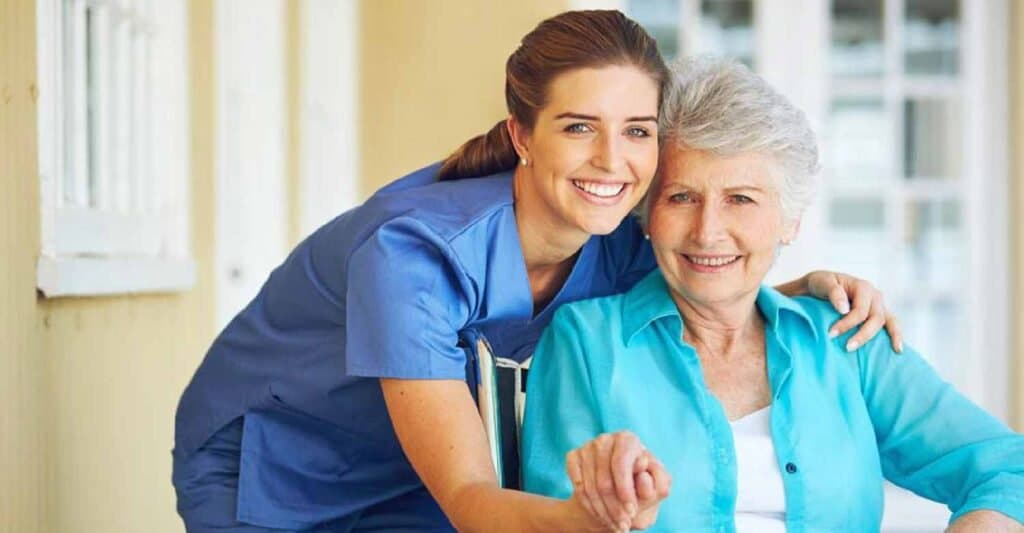 Home care worker hugging a smiling senior woman