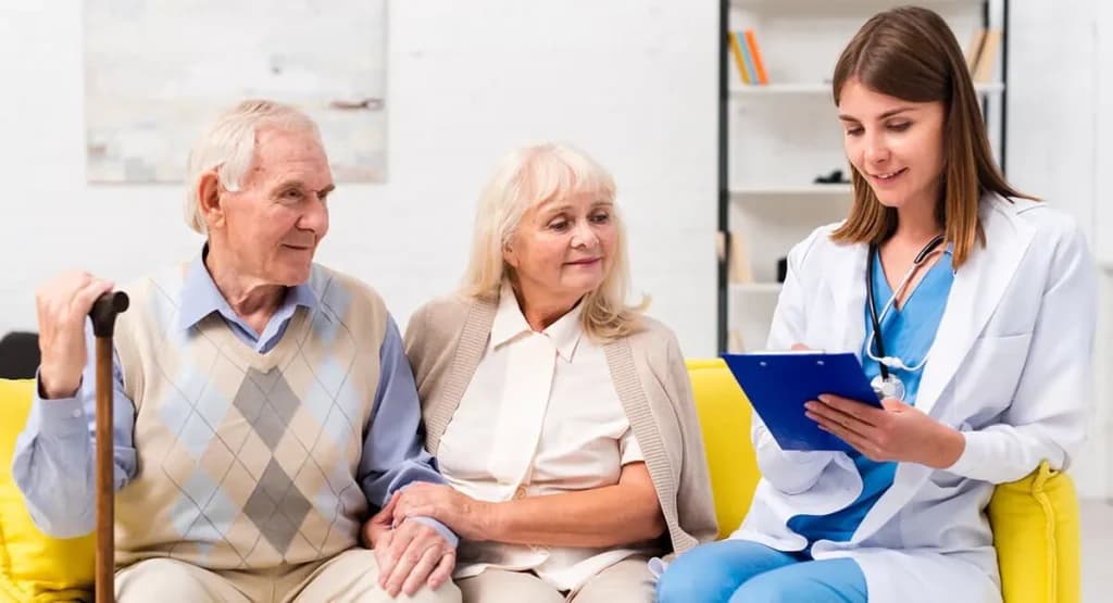 Home health care nurse with a clipboard talking to a senior couple