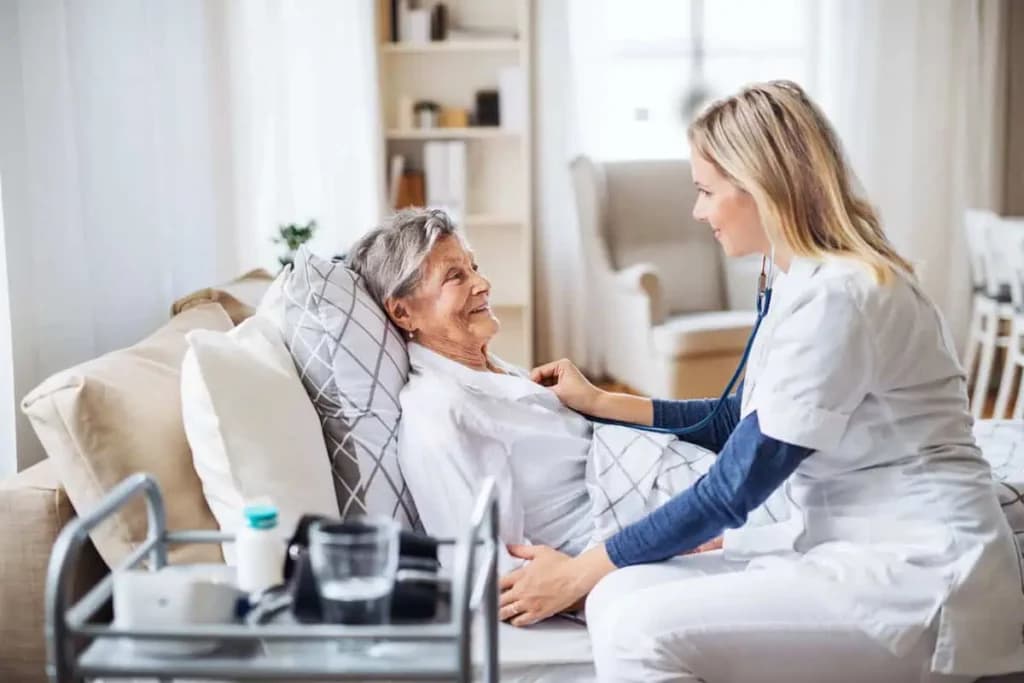 Home help care worker sitting with an older woman at home
