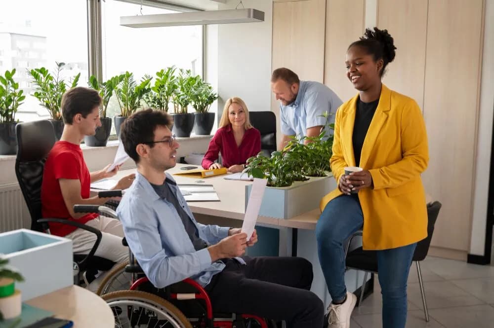 Support worker with a group that includes a man using a wheelchair