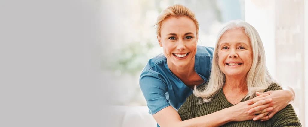 Care worker embracing a smiling older woman